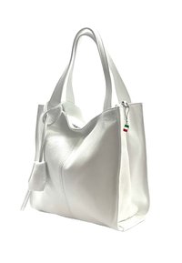 Witte lederen tote bag met een gestructureerd oppervlak, diagonale stiksel, en een klein charm met de kleuren groen, wit en rood vastgemaakt aan de rits.