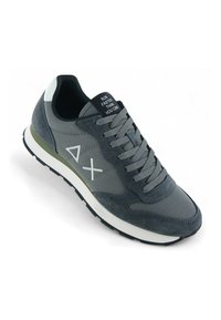 Scarpa da atletica grigia realizzata con una combinazione di suede e materiali tessili, con dettagli bianchi, lacci rotondi e suola in gomma nera con scanalature.