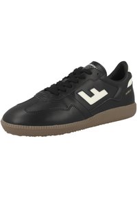 Sneaker nera in pelle con finitura testurizzata, caratterizzata da un'accensione con logo bianco e suola in gomma marrone con un motivo scanalato. Design con lacci.