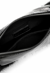 Black faux fur clutch bag, featuring a zip closure. Inner lining is smooth black fabric with an additional zip pocket.