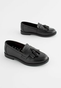 Mocassins en cuir noir avec un gland décoratif à l'avant, bout arrondi et semelle cousue. Texture lisse et talon bas.