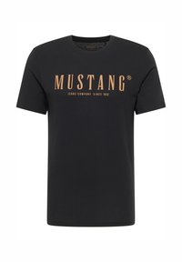 Czarna bawełniana koszulka z krótkim rękawem, z dużym pomarańczowym logo "MUSTANG" oraz napisem "JEANS COMPANY SINCE 1932". Prosty design.