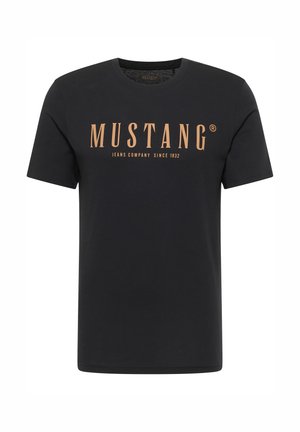 Fekete pamut rövid ujjú póló, nagy narancssárga "MUSTANG" logóval és "JEANS COMPANY SINCE 1932" felirattal. Egyszerű dizájn.