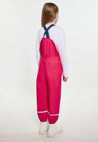 Ružové vodoodpudivé overal s nastaviteľnými modrými popruhmi, elastickým pásom a reflexnými pruhmi na koncoch rukávov. Nosia sa biele topánky.