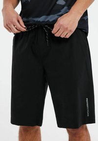 Mustat pyöräilyshortsit, jotka on valmistettu kevyestä kankaasta. Niissä on joustava vyötärö naruineen ja logo vasemmassa lahkeessa.