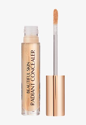 Radiant concealer in a transparent tube with gold accents, featuring a soft applicator wand and a cream-colored liquid formula.