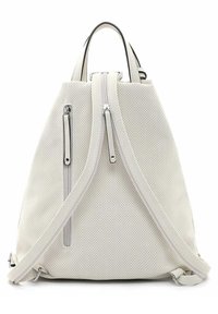 Mochila blanca perforada con cremalleras plateadas, dos bolsillos laterales y una forma curva. Cuenta con correas ajustables y un asa en la parte superior.