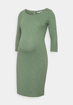 Maternity dress in textured green fabric, featuring a scooped neckline and three-quarter sleeves, designed to fit over a growing belly.