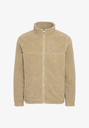 Beige színű polárdzseki cipzárral az elején, magas gallérral, két elülső zsebbel és egy diszkrét logóval a mellkason. Puha, texturált felület.