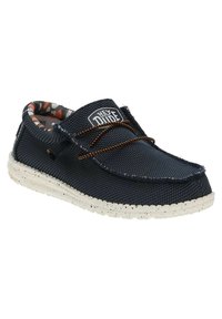 Zapatilla de lona navy con un upper texturizado, cordones naranjas y una suela blanquecina moteada. El forro interior presenta un patrón colorido. Diseño casual.