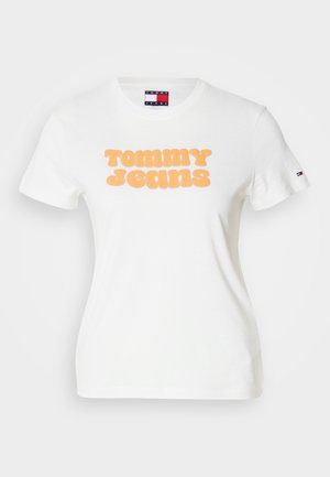 Valkoinen t-paita, jossa on suuri oranssi teksti, joka lukee "TOMMY JEANS." Lyhyet hihat, joissa on pieni logoakkentti vasemmassa hihassa. Puuvillamateriaali.