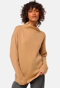 Beige gerippter Pullover mit hohem Kragen und locker geschnittenen Ärmeln, aus weichem Strickmaterial gefertigt. Verfügt über eine entspannte Silhouette und ein strukturiertes Muster.