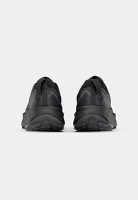 Zwarte sportieve schoenen met een bovenwerk van mesh en synthetisch materiaal, gestructureerde oppervlakken, ronde hakken en rubberen zolen, met dubbele trekbanden.