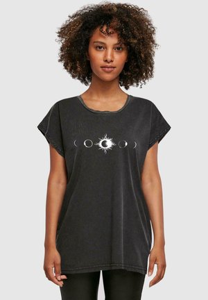 Schwarzes, oversize T-Shirt aus weichem Baumwollstoff mit einem zentralen Sonnen- und Mondmotiv. Kurze Ärmel, runder Ausschnitt und lockere Passform.