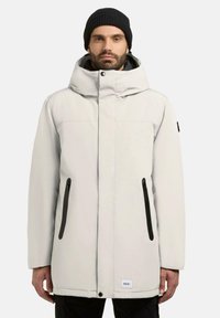 Lysegrå parka-jakke med hætte, der har sorte lynlåslommer, minimalistisk design og et sort mærke ved kanten. Struktureret stof.