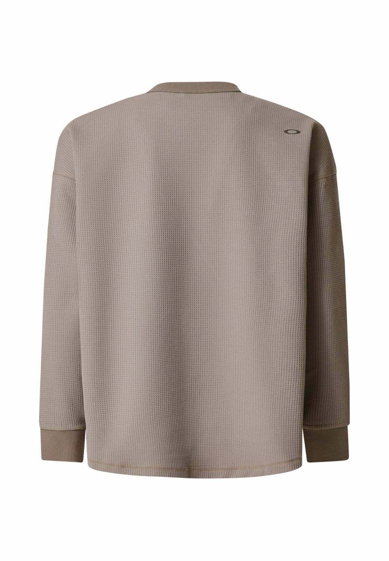 Brown long-sleeve shirt made of textured fabric, featuring a relaxed fit, dropped shoulders, and a small logo on the upper back.