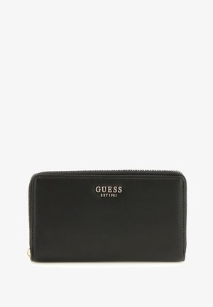 Portafoglio in pelle nera con chiusura zip, logo dorato "GUESS EST1981" e una texture liscia senza motivi visibili.