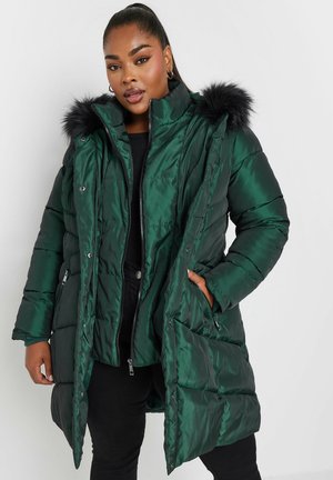 Groene satijnen pufferjas met een capuchon met bontafwerking, rits- en drukknoopsluiting, en zijzakken. Heeft een quiltpatroon en een ontspannen pasvorm.