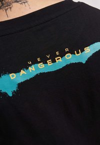 Juodas marškinėliai su ryškiu tekstu "4EVER DANGEROUS" geltona spalva, uždengtu turkio spalvos purslais, pagaminti iš minkštos medvilnės.