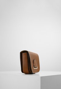 Lædertaske i tan-farve med rektangulær form, som har en glat tekstur, afrundet klap og detaljer i guldfarve.