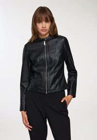 Giacca in pelle nera con un design aderente, colletto alto e chiusura frontale con zip. Presenta dettagli delle cuciture e maniche lunghe.