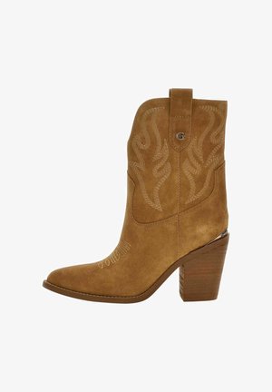 Stivale da cowboy in camoscio color senape con cuciture in stile Western, tacco impilato in legno di altezza media e linguetta con logo "G" sulla parte superiore.