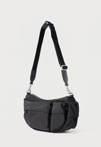 Fekete nejlon válltáska állítható pánttal, cipzáras záródással, két első zsebbel és letisztult, lekerekített kialakítással.