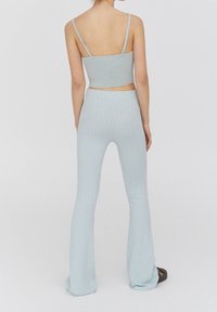 Ensemble deux pièces côtelé bleu clair, comprenant un débardeur court à fines bretelles et un pantalon évasé, tous deux dotés d'une texture douce.