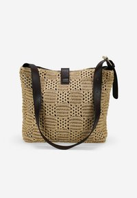 Bolso tejido en color tostado con un patrón intrincado, acentuado con una correa de cuero marrón oscuro y un cierre con lengüeta en la parte superior.