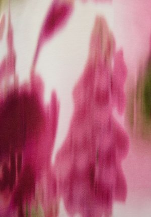 Motif de tissu abstrait présentant des nuances de rose, avec des formes florales floues et une texture douce sur un fond clair.