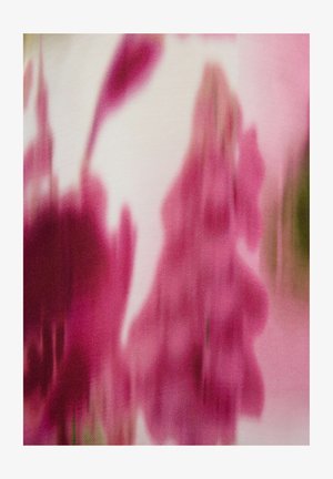 Motif de tissu abstrait présentant des nuances de rose, avec des formes florales floues et une texture douce sur un fond clair.