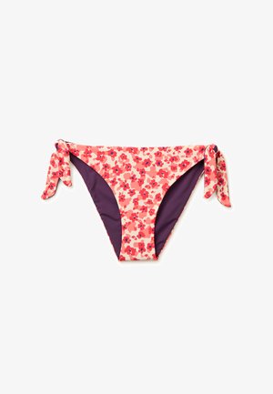 Bas de bikini floral rose et rouge avec fermetures latérales à nouer et doublure intérieure violette, présenté sur fond blanc.