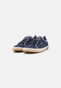 Marineblå kanvas sneakers med hvite detaljer, snøring, og midtsåle i jute, med gummisåle for godt grep.