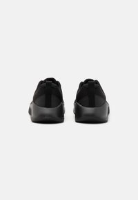 Schwarze Sportschuhe mit einem Mesh-Obermaterial, abgerundeter Zehenpartie, Zuglaschen und strukturierten Sohlen für verbesserten Halt. Schlichtes, elegantes Design.