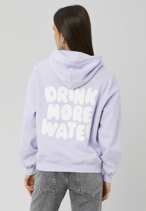 Sweat à capuche violet avec un grand texte blanc au dos indiquant « BOIS PLUS D'EAU ». Il présente une coupe décontractée et une capuche à cordon.