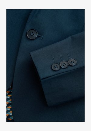 Mörkblå kostymtyg med en strukturerad mönster; har en tre-knappsknapp i glänsande svart plast och ett geometriskt tryckfoder i orange och blått.