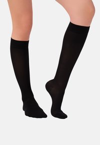 Knielange, schwarze Socken aus glattem Material. Sie haben eine einfarbige Oberfläche mit einem bequemen, gerippten Bund und einer verstärkten Zehenpartie.