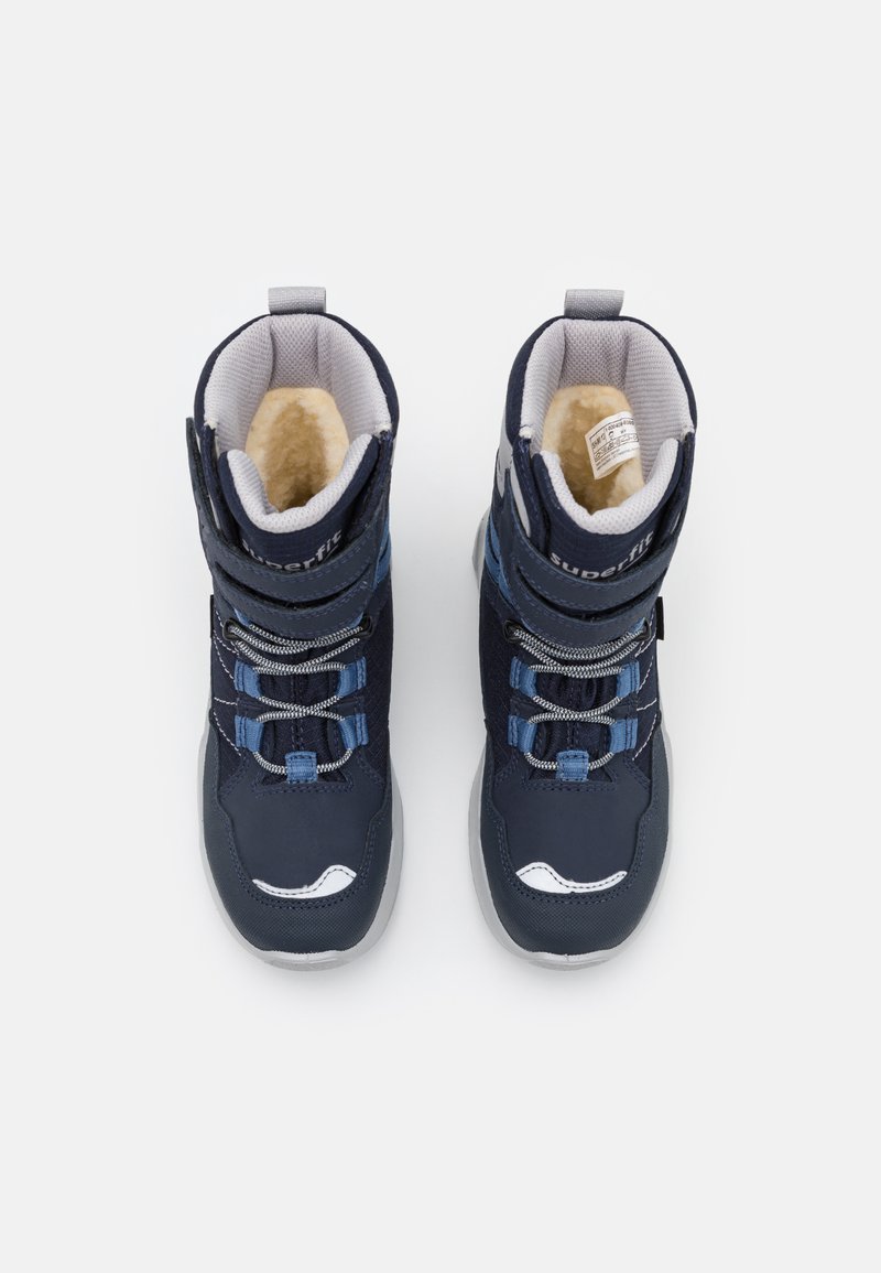 Dunkelblaue Winterstiefel mit einem weichen beigen Futter, ausgestattet mit einer Schnürung und Hakenverschluss, gepolsterter Knöchelunterstützung und weißen Akzentdetails.