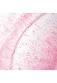 Gel clair avec des bulles et des gouttelettes roses en suspension, créant un aspect texturé et translucide avec une teinte rose douce.
