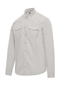 Camicia a maniche lunghe grigia chiara con colletto, chiusura frontale con bottoni e due tasche sul petto con bottoni a scatto. Tessuto dalla texture liscia.