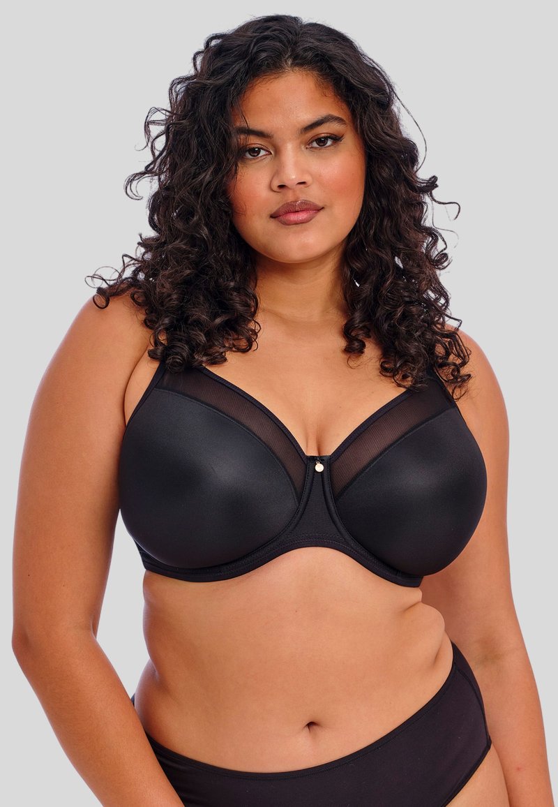 Soutien-gorge noir avec des bonnets lisses et rembourrés, orné de détails en maille transparente et d'un embellissement central. Comprend des bretelles larges et des bords sans couture.