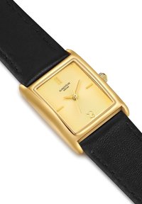 Reloj rectangular dorado con una esfera amarilla texturizada y correa de cuero negra. Presenta marcadores de hora minimalistas y una corona.