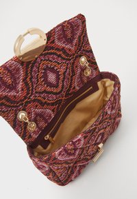 Kootud käekott violetsetes, oranžides ja kuldsetes toonides, mustrilise välispinnaga, kuldsete detailidega ning sisemise tõmblukuga taskuga.