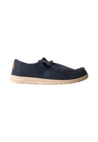 Chaussure décontractée bleu marine à enfiler avec tige en tissu texturé, semelle beige et détail lacet élastique sur fond blanc.