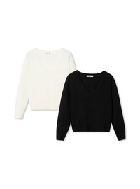 Dwa swetry z długim rękawem i dekoltem w serek, jeden biały, a drugi czarny, leżące płasko na białym tle.