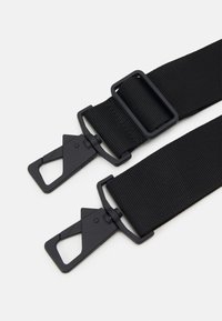 Due cinturini neri in nylon regolabili con slider rettangolari e ganci a moschettone girevoli su uno sfondo bianco.