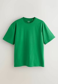 T-shirt vert uni à manches courtes et col rond de taille moyenne présenté sur un fond clair.