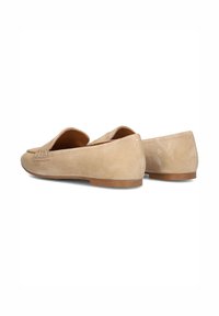 Beige suède loafers met een platte hak, met een gestikte accent op de bovenkant en een afgeronde teenzool. Glad textuur overal.