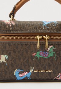 Brązowa torebka w wzory z kolorowymi motywami koni; złote okucia z podwójnymi suwakami, teksturowany materiał i uchwyt do noszenia.