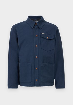 Navy blue cotton jacket with a collar, front buttons, two large front pockets, and a chest pocket. Features brown metal accents.